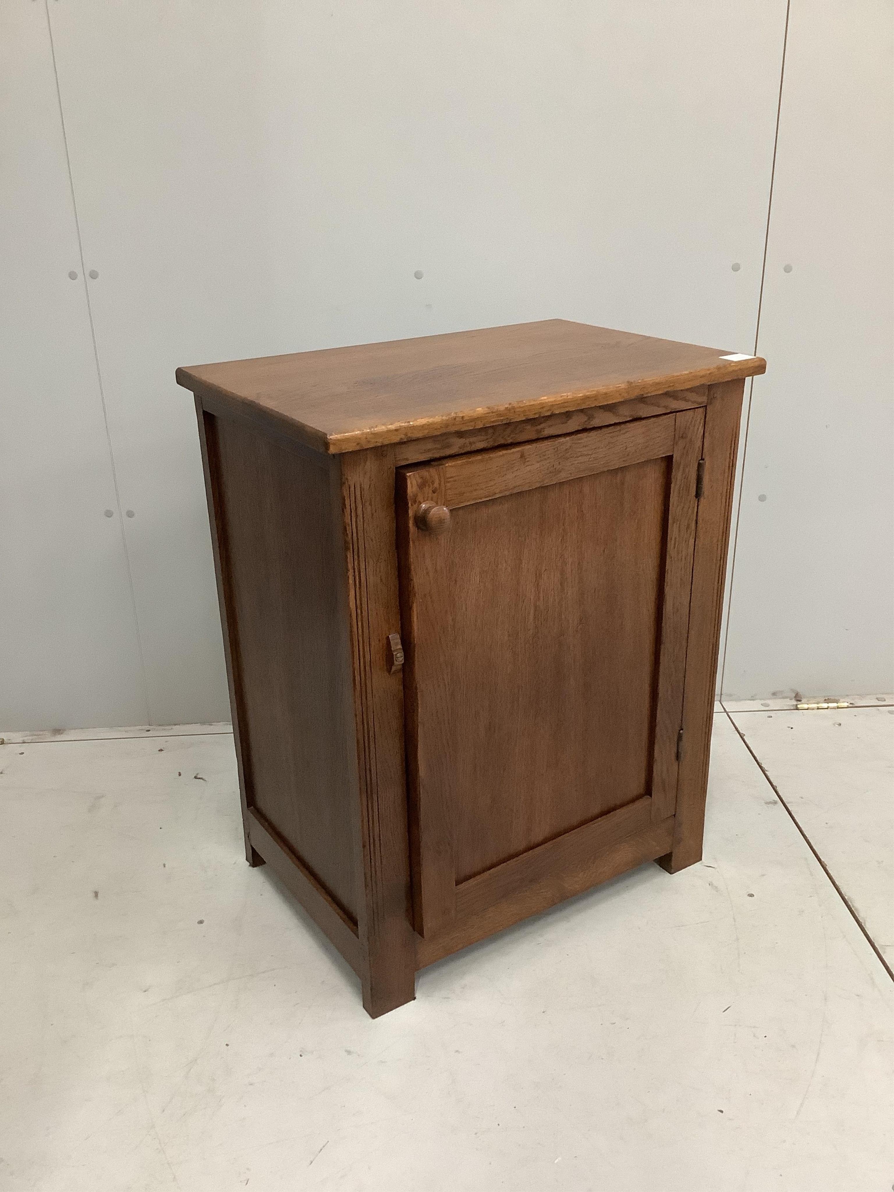 A near Contemporary oak cupboard, enclosed by a panelled door, width 68cm, height 84cm. Condition - light scuffs, otherwise good